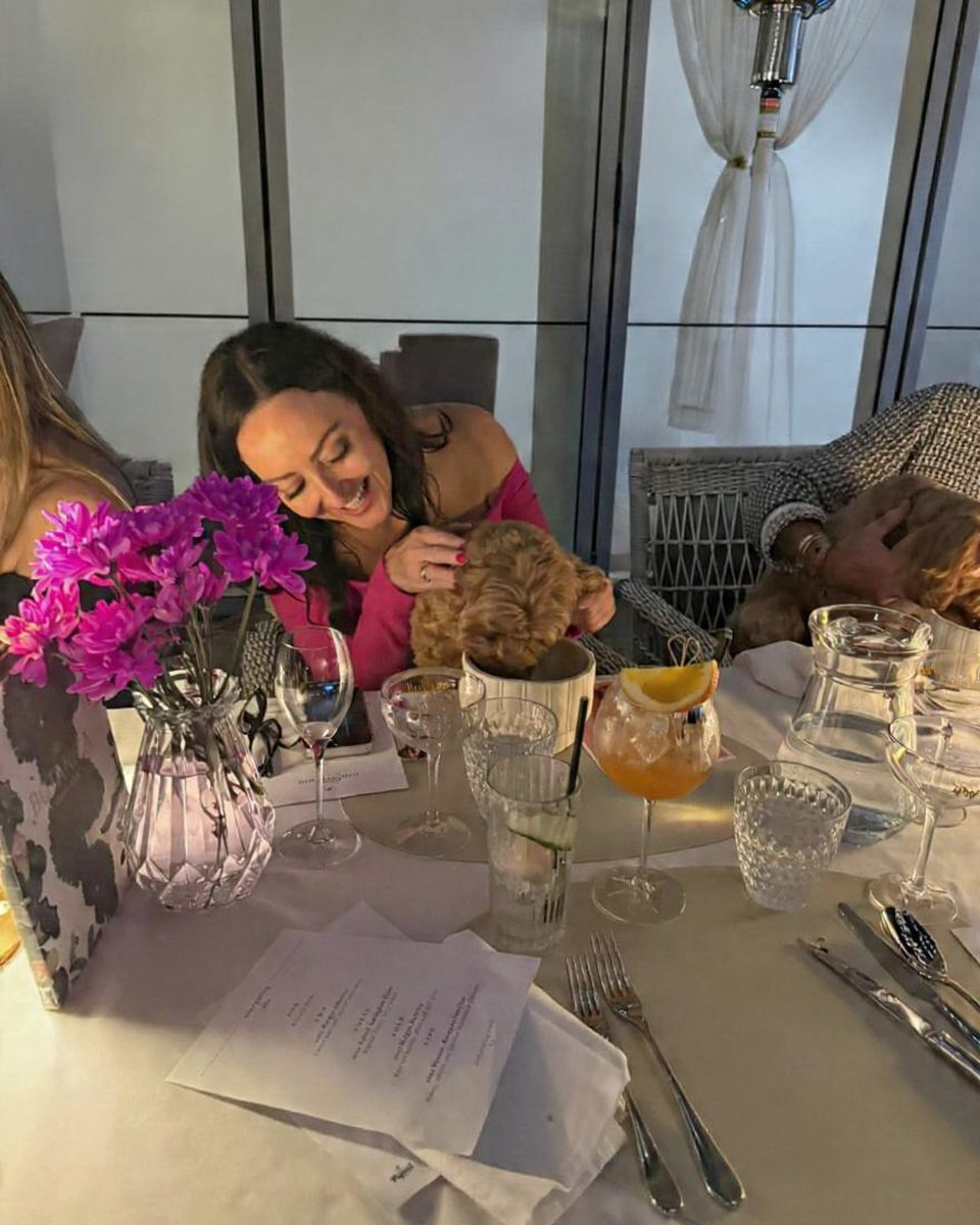 A guest cuddling a dog at the table