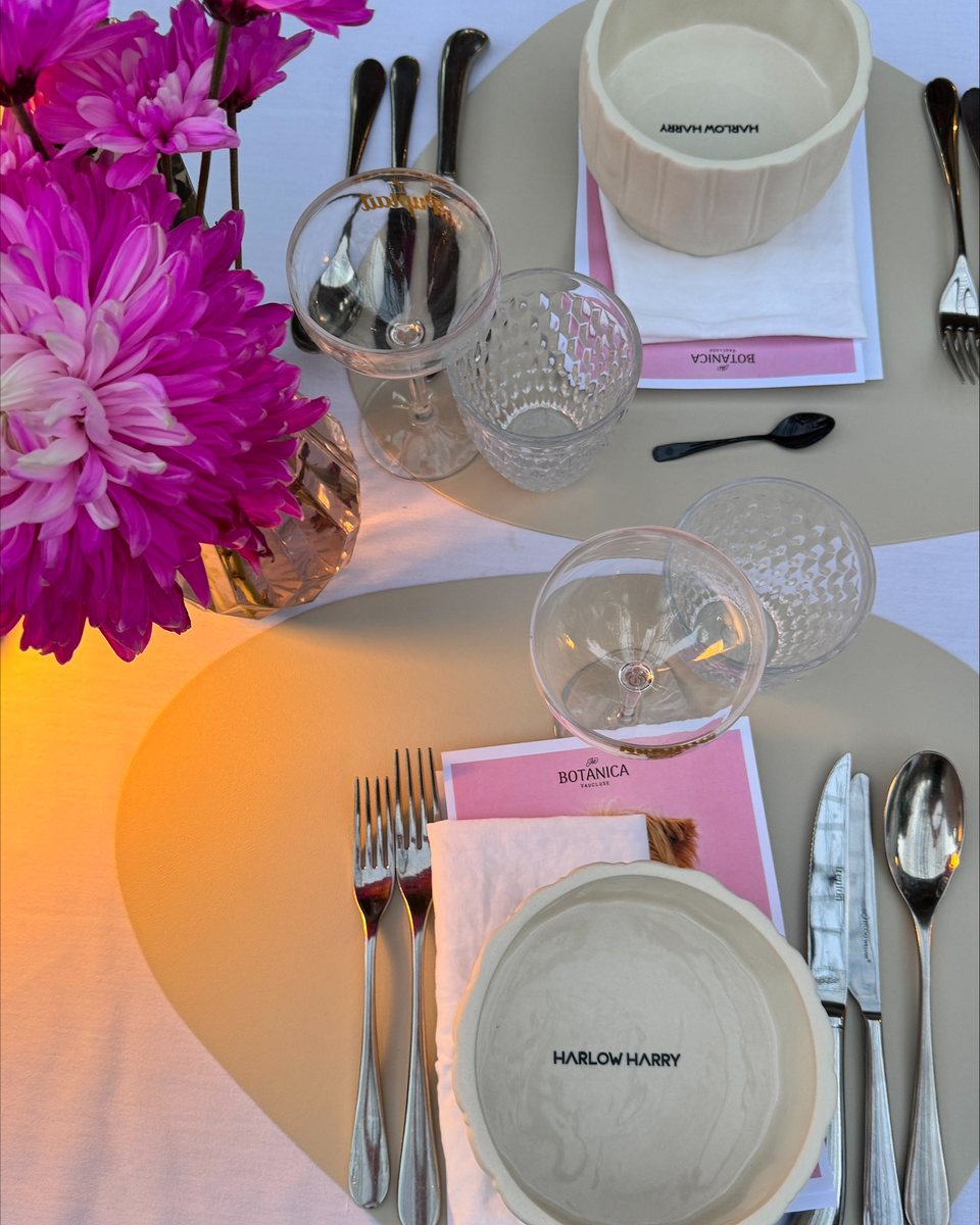 A place setting with pink flowers and a dog bowl
